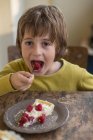 Хлопчик їсть полуничний пиріг — стокове фото