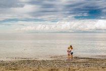 Маленькие девочки стоят на пляже — стоковое фото