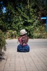 Дівчина сидить на тротуарі — стокове фото