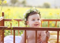 Toddler sitting in crib outdoors — Stock Photo
