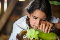 Chica descascarillado maíz - foto de stock