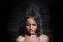 Girl under outdoor shower — Stock Photo