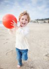 Мальчик с мячом на пляже — стоковое фото