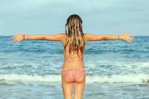 Girl on beach with outstretched arms — Stock Photo