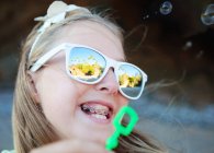 Girl blowing bubbles — Stock Photo