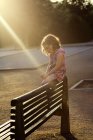 Дівчина сидить на лавці — стокове фото
