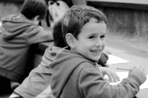 Rapaz da felicidade sorrindo enquanto desenha — Fotografia de Stock
