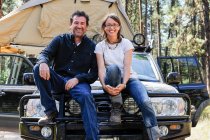 Paar sitzt auf Motorhaube von Auto — Stockfoto