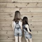 Girls wearing dungarees standing side by side — Stock Photo