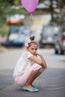 Chica triste sosteniendo globo rosa - foto de stock