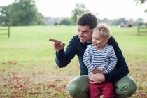 Отец обнимает сына в парке — стоковое фото