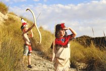 Menina e menino brincando vestidos de índios — Fotografia de Stock