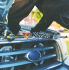 Чоловік ремонтує двигун автомобіля — стокове фото
