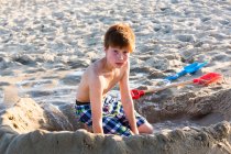 Vermelho peludo menino jogando na praia — Fotografia de Stock