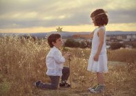 Мальчик преклонил колени перед девочкой — стоковое фото