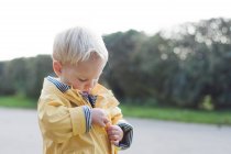 Мальчик застегивает пальто — стоковое фото