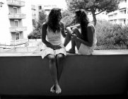 Jóvenes gemelas hablando al aire libre - foto de stock