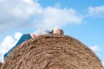 Мальчик лежит на тюке сена — стоковое фото