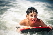 Niño surfeando en el mar - foto de stock