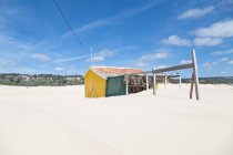 Cabaña de playa abandonada en la arena - foto de stock