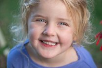 Blondes Mädchen im lila Pullover lächelt — Stockfoto