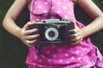 Девушка держит винтажную камеру — стоковое фото