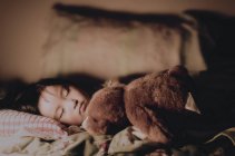 Mädchen schläft mit Teddybär — Stockfoto