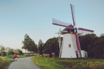 Man standing on road next to windmill — Stock Photo