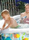 Father and son playing in pool — Stock Photo