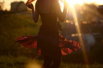 Молода жінка танцює на заході сонця — стокове фото
