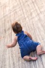 Baby crawling on wooden surface — Stock Photo