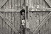 Bambini che guardano fuori da dietro la porta — Foto stock