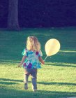 Chica sosteniendo globo en fiesta de cumpleaños - foto de stock