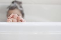 Weibliche Zehen aus der Badewanne betrachtet — Stockfoto