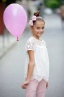 Menina feliz segurando balão rosa — Fotografia de Stock