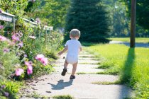 Хлопчик біжить уздовж тротуару — стокове фото