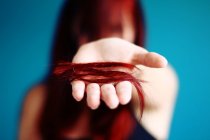 Женщина держит отрезанные волосы за руку — стоковое фото