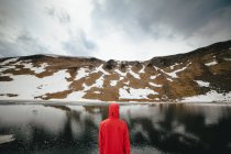 Uomo guardando lago di montagna — Foto stock