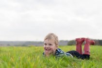 Хлопчик лежить у траві — стокове фото