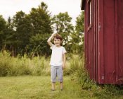 Хлопчик стоїть на відкритому повітрі біля сараю — стокове фото