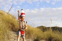 Junge im Indianerkostüm steht auf Feld — Stockfoto