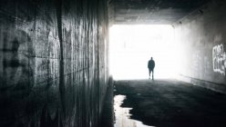 Uomo che cammina attraverso il tunnel — Foto stock