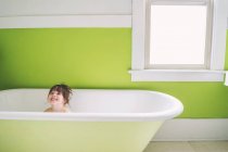 Baby girl sitting in bathtub — Stock Photo