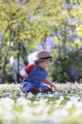 Хлопчик в капелюсі сидить на траві — стокове фото