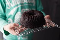 Menino segurando bolo de esponja de chocolate — Fotografia de Stock