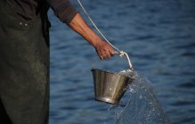 Fisherman holding bucket — Stock Photo