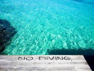 Quai au bord de la mer avec No Diving — Photo de stock