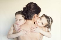 Madre abrazándose con sus hijos - foto de stock