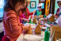Children decorating gingerbread houses — Stock Photo