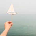 Mano de mujer sosteniendo un barco de papel - foto de stock